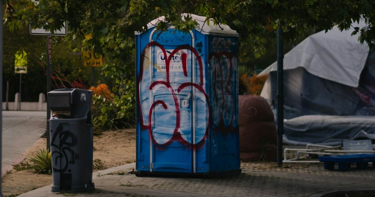 Man Tips Port-A-Potty, Traps 2
